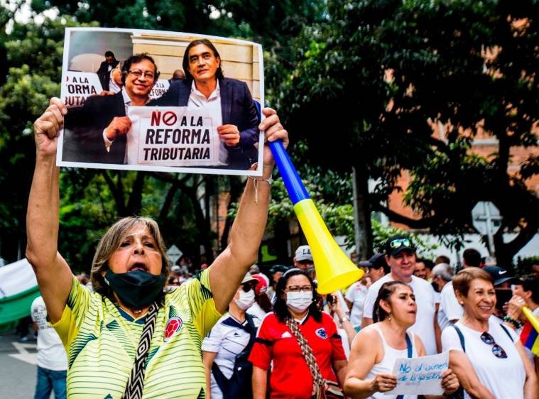 Una de las manifestantes exhibe una de las fotografías cuando Petro y Bolívar protestaron contra la Reforma Tributaria de Iván Duque.